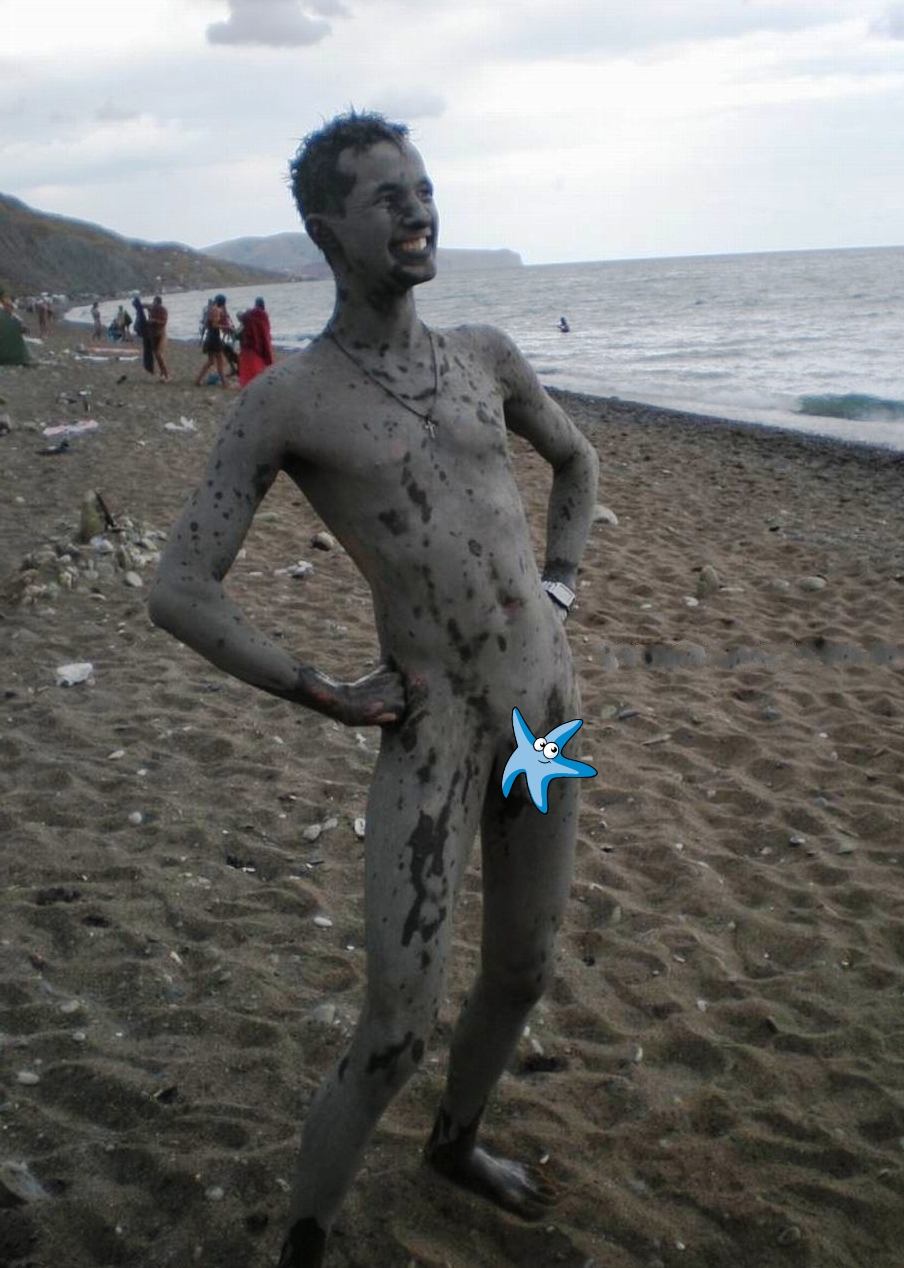 Nude boy covered in mud